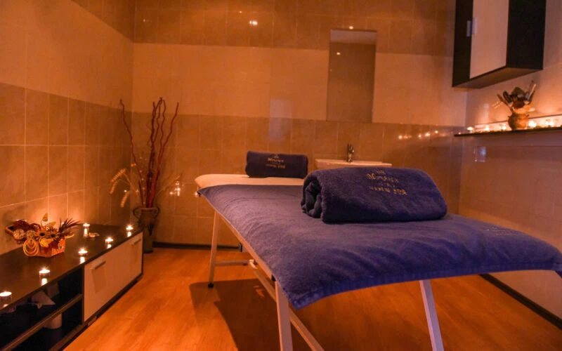 СПА рутина в хотел Айсберг Банско. СПА стая с масажна маса, уютна обстановка и романтична светлина в хотел Айсберг Банско.